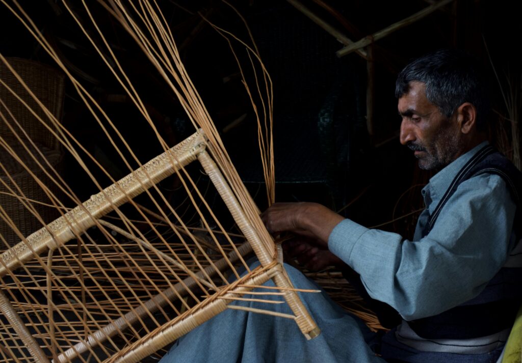 a man weaving a bamboo basket